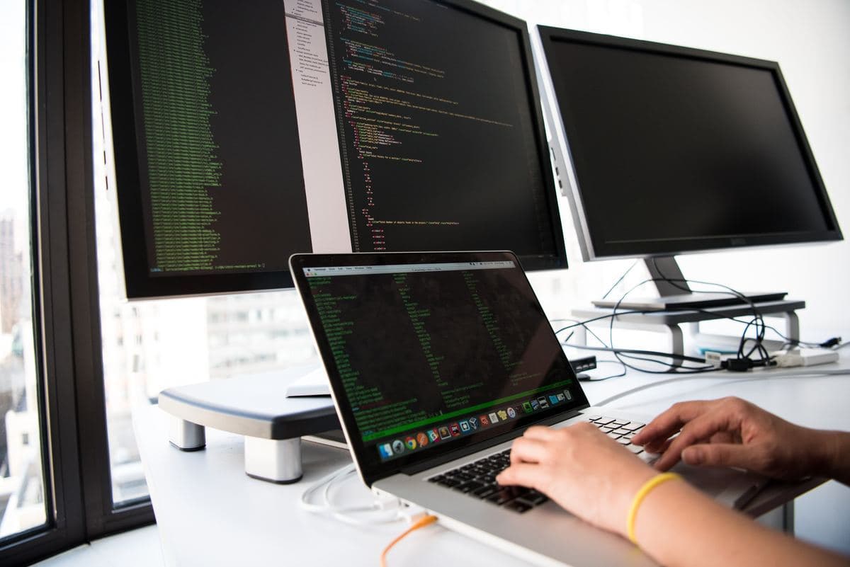 A person focused on typing on a laptop computer, with hands positioned over the keyboard.