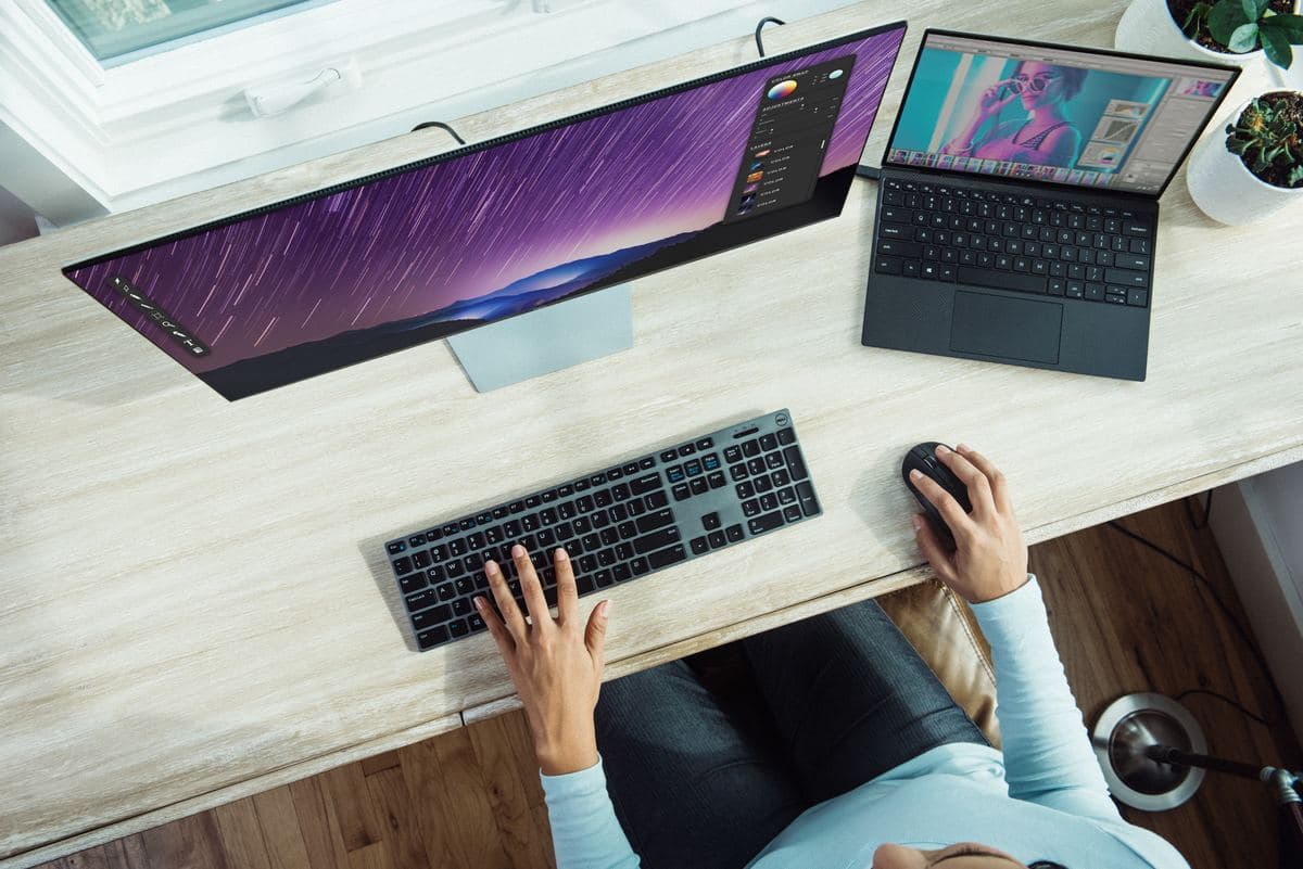 A woman focused on her laptop, typing on a keyboard with a thoughtful expression.